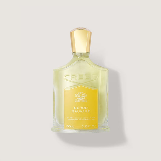 Frasco de perfume Creed Neroli Sauvage de 100 ml en un fondo fondo beige claro.